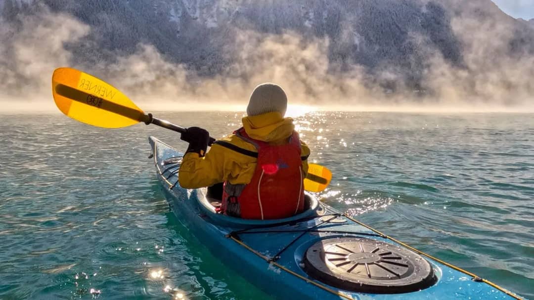 Kayak en invierno sobre las aguas turquesa del lago de Brienz en Interlaken, rodeado de cumbres nevadas
