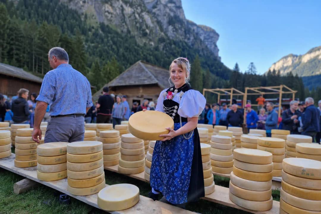 Daniela Thierstein with alpine cheese wheels in traditional Bernese costume, Justistal Switzerland
