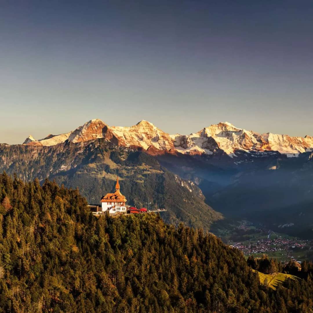 Harder Kulm summit restaurant above Interlaken with Eiger Mönch and Jungfrau at golden hour, Bernese Oberland Switzerland