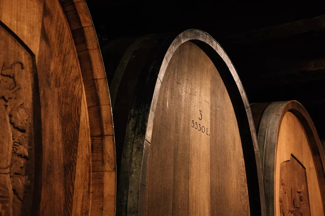 Carved 5530 litre oak casks in the Rebbau Spiez cellar, where Spiezer wine is aged above Lake Thun