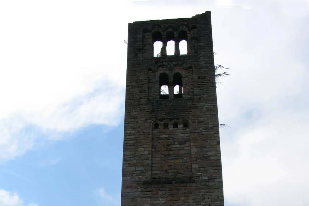 Upper storeys of the Goldswil ruin tower with their arched windows seen from below against a bright sky
