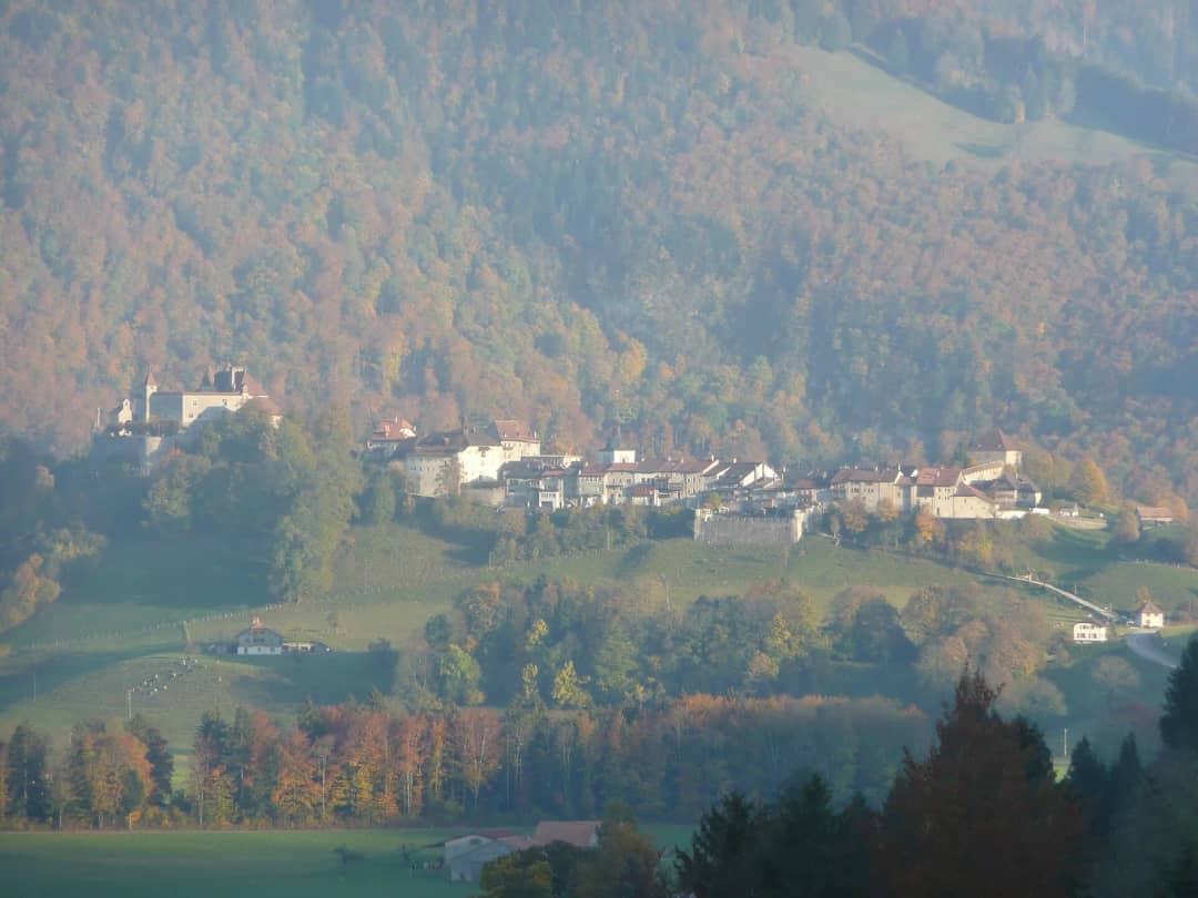 Städtchen und Schloss Gruyères auf dem Hügel über Herbstwäldern, bekannter Halt bei Alpbesuchen in der Schweiz