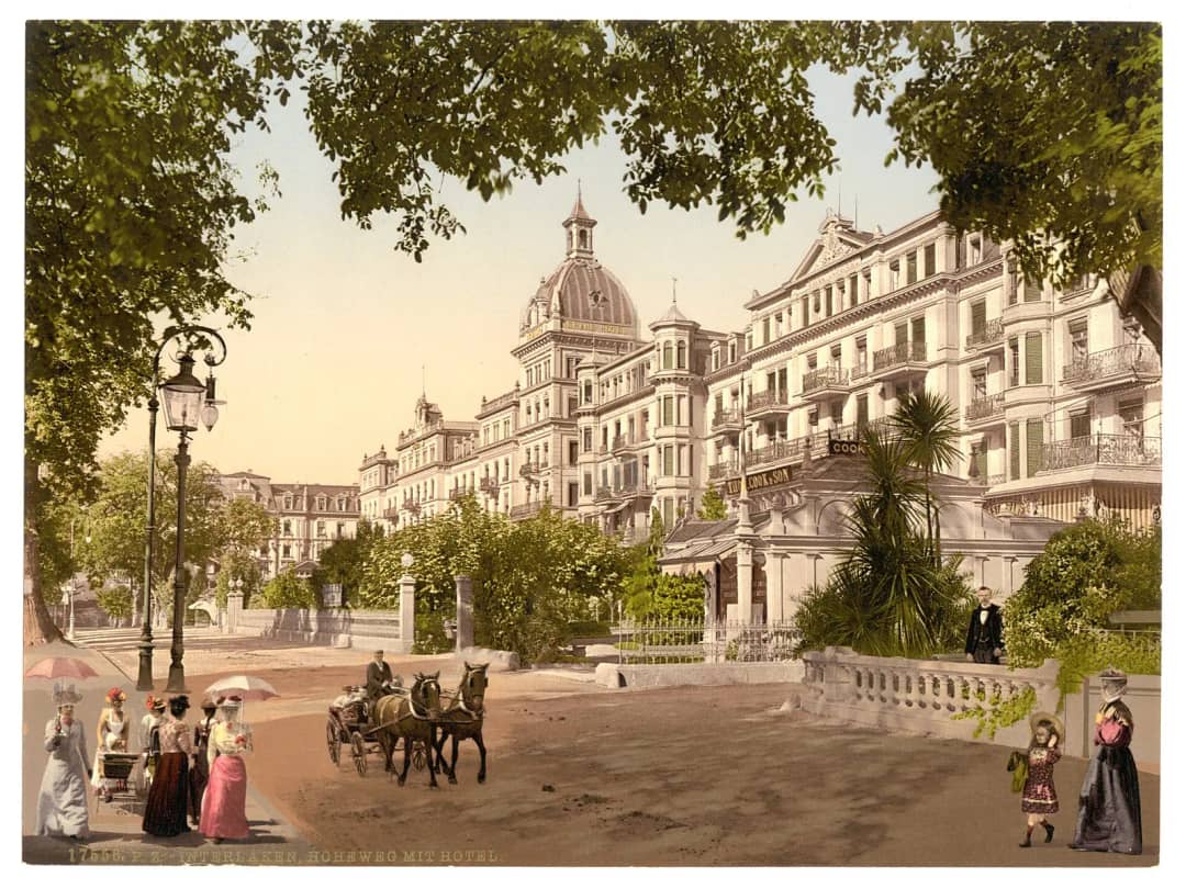 Fotocromo del Höheweg hacia 1890, con grandes hoteles y carruajes junto a la Höhematte de Interlaken salvada