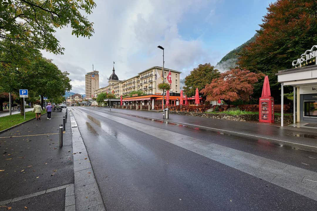 Der Höheweg im Zentrum von Interlaken mit Hotels und Bäumen an einem grauen Tag, Start der Weintour nach Spiez