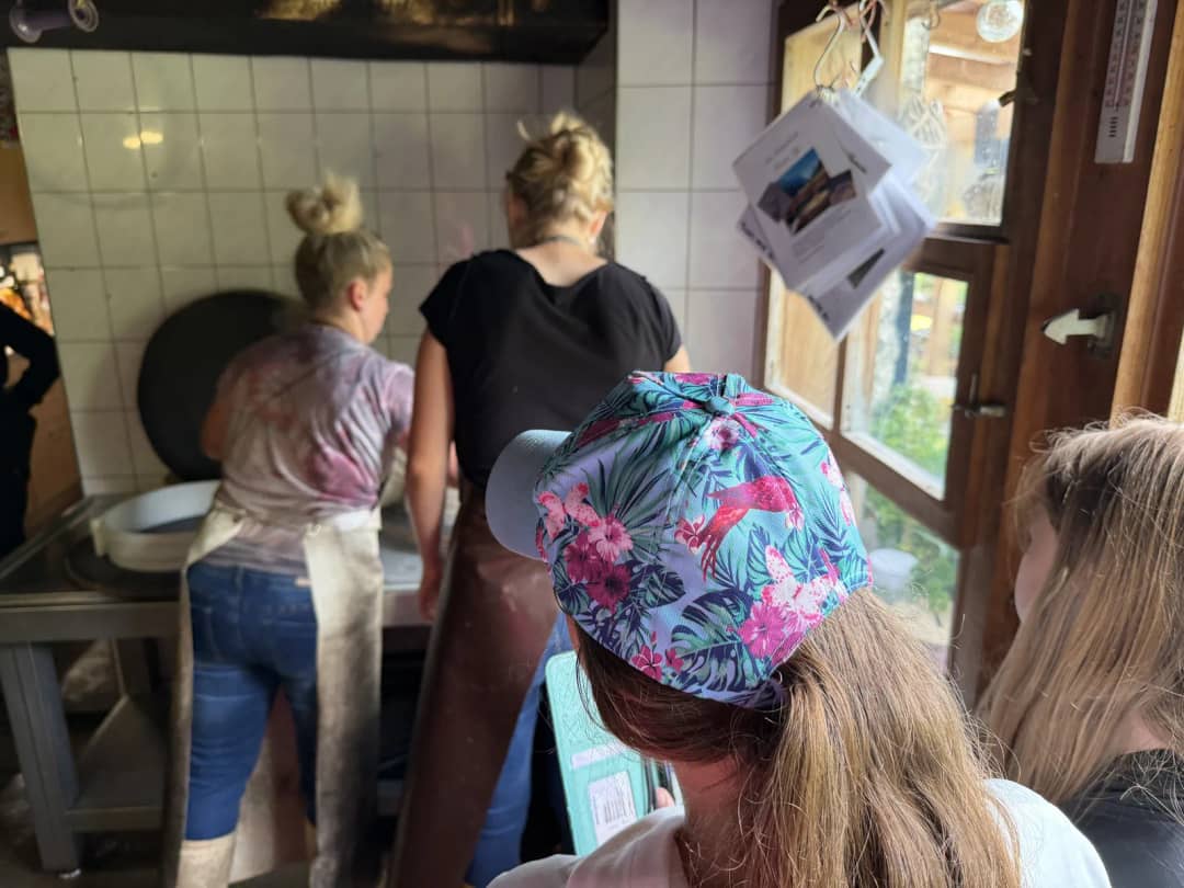 Guests gathered round the farmer in the tiled alp dairy, where each answer gets translated on the farm tour