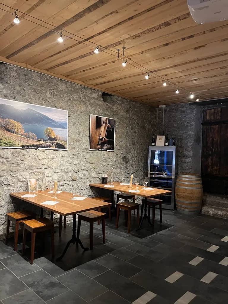Salle de dégustation de la coopérative viticole de Spiez et ses tables en bois, une option près d'Interlaken
