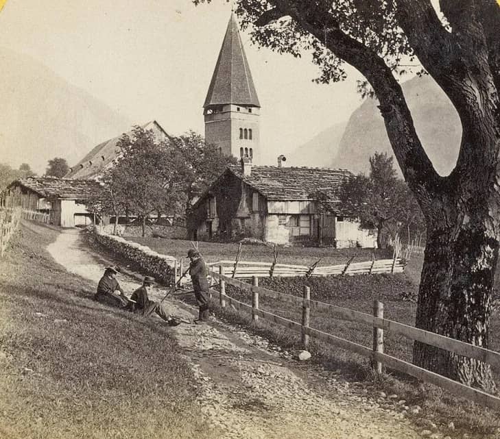 Old stereo photograph of a street in Meiringen with the church tower, the village of the meringue legend