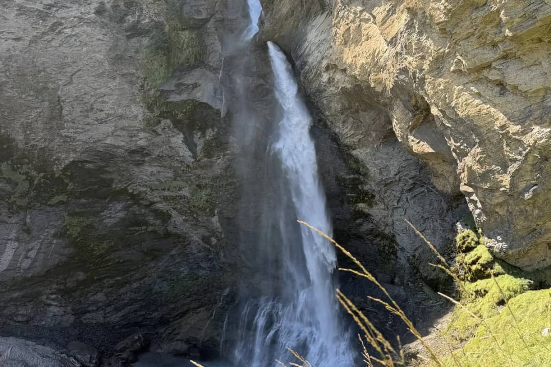 Der Reichenbachfall stürzt zwischen grauen Felswänden oberhalb Meiringen, vom Aussichtspunkt im Augustlicht