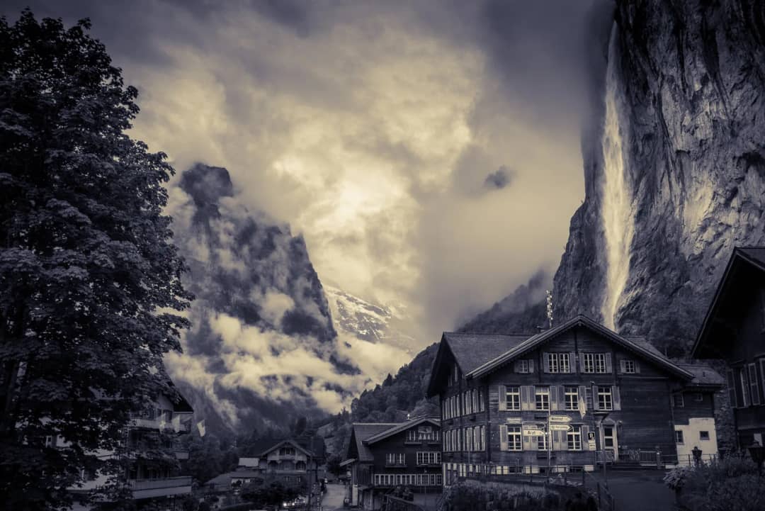 El pueblo de Lauterbrunnen bajo el acantilado con la cascada del Staubbach junto a los chalés del valle
