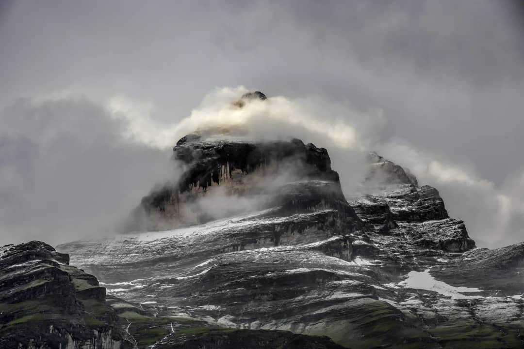 Cloud rolling over the high cliff walls above the Lauterbrunnen valley on a changeable summer day