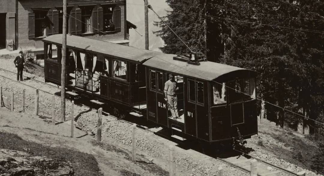Una fotografía antigua de un tren del ferrocarril de montaña Lauterbrunnen Mürren en su pequeña estación