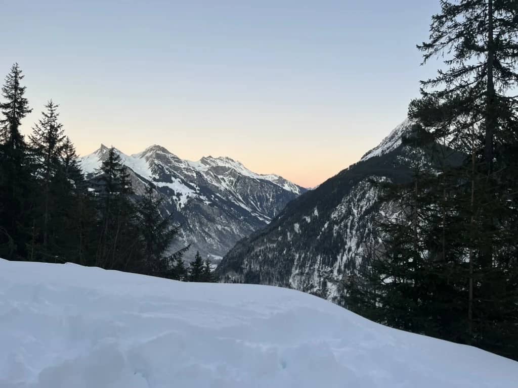 Un camino forestal nevado entre Sulwald e Isenfluh al atardecer en diciembre, abetos y picos en la última luz