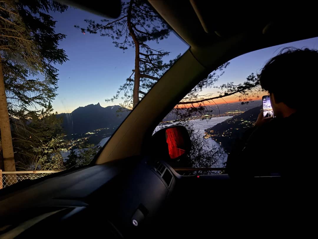 La vista desde la furgoneta en el camino de vuelta sobre el lago de Thun de noche, luces de la orilla abajo
