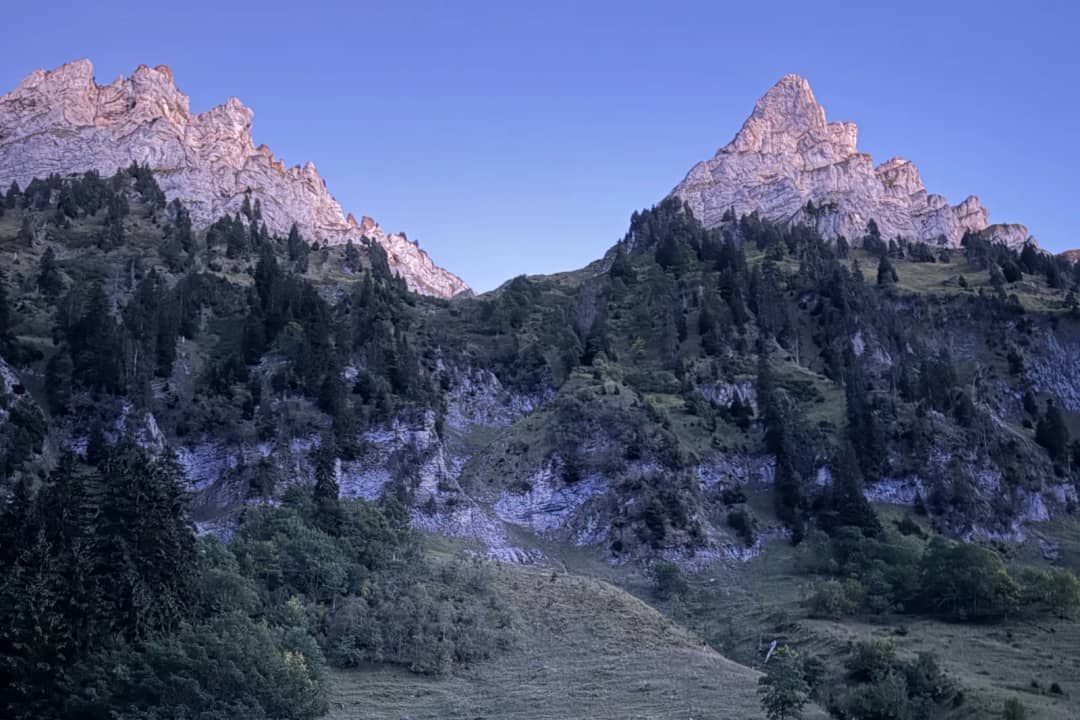 Las crestas rocosas del Justistal tiñéndose de rosa al atardecer de septiembre, con el valle en sombra