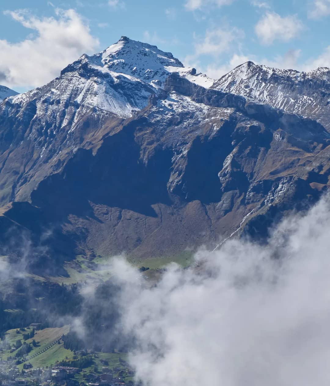 The Schilthorn summit and Birg station above Mürren, with clouds rising out of the Lauterbrunnen valley