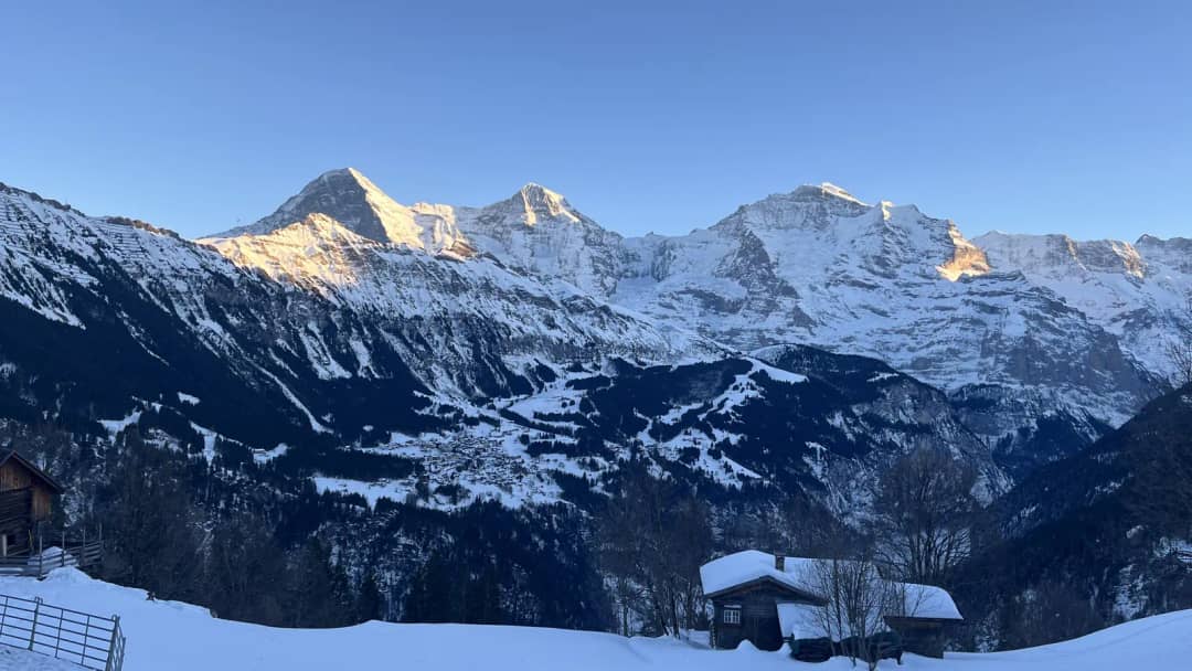 El Eiger, el Mönch y la Jungfrau al último sol sobre chalés nevados en Sulwald, invierno en Interlaken
