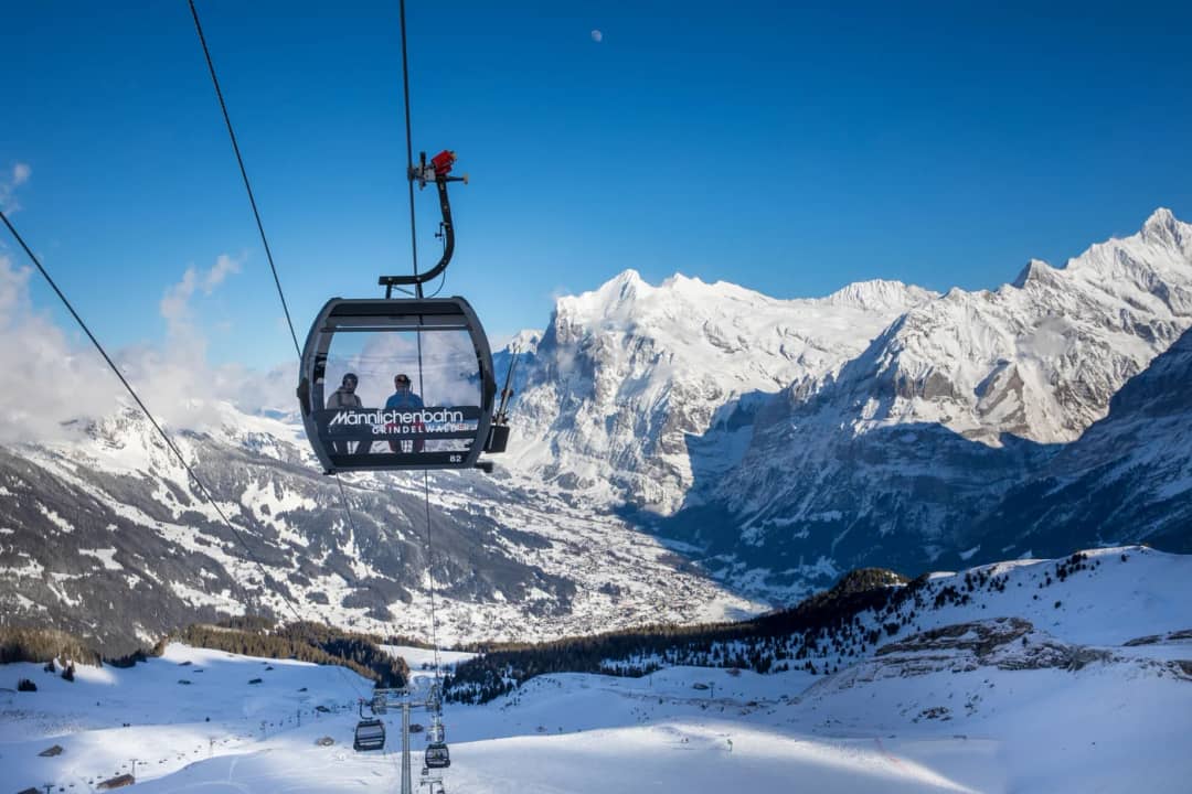Skifahrer in einer Kabine der Gondelbahn Grindelwald-Männlichen vor dem Wetterhorn, Skigebiet Männlichen
