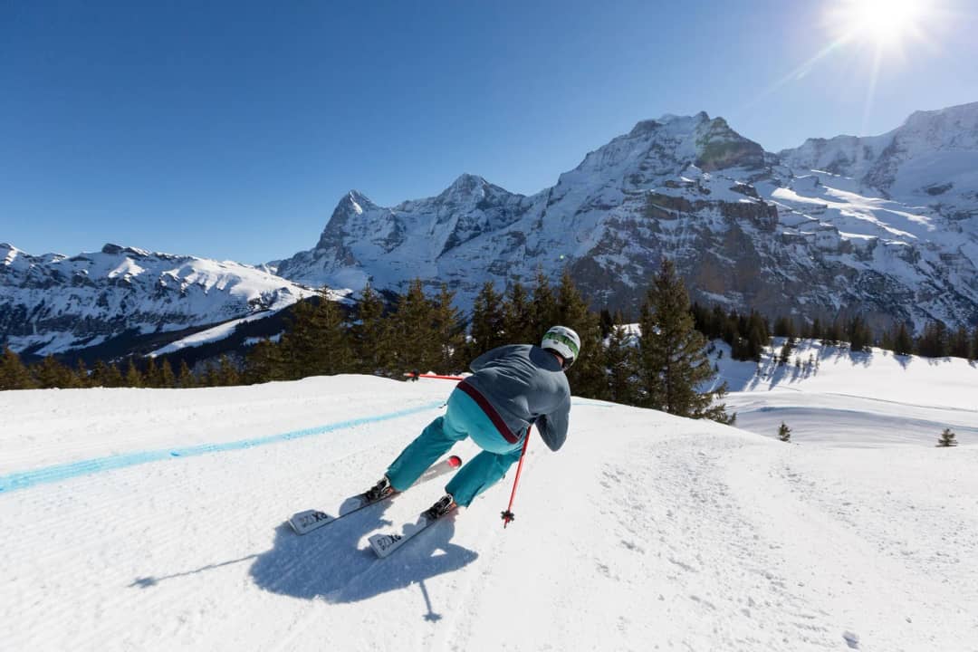 Ein Skifahrer auf der Skicross-Piste von Mürren-Schilthorn, in der Ferne Eiger und Mönch, Skigebiet Mürren