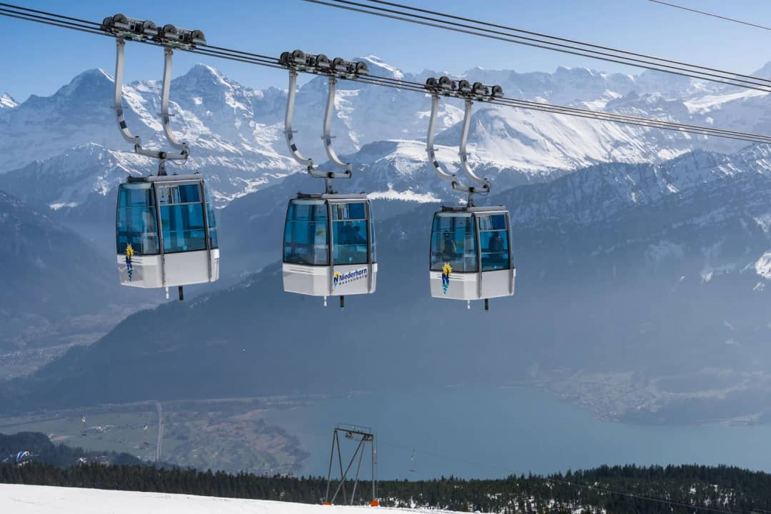 Cabinas de la góndola del Niederhorn sobre el lago de Thun en un claro día de invierno, el remonte del billete de día de trineo de CHF 49