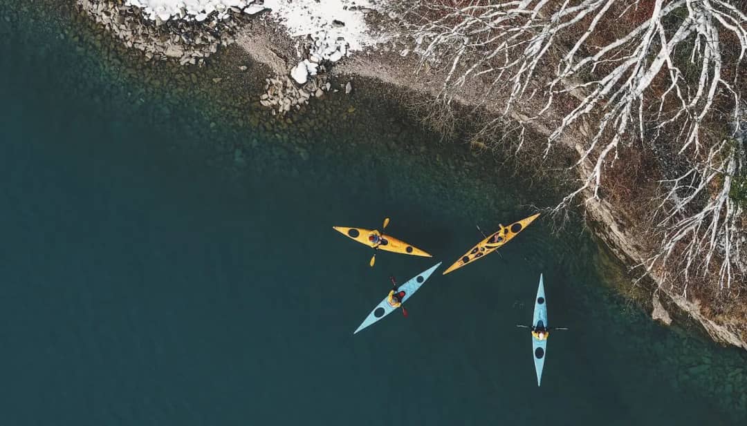 Vista aérea de kayaks junto a una orilla nevada y arbolada del lago de Brienz, cerca de Bönigen en invierno