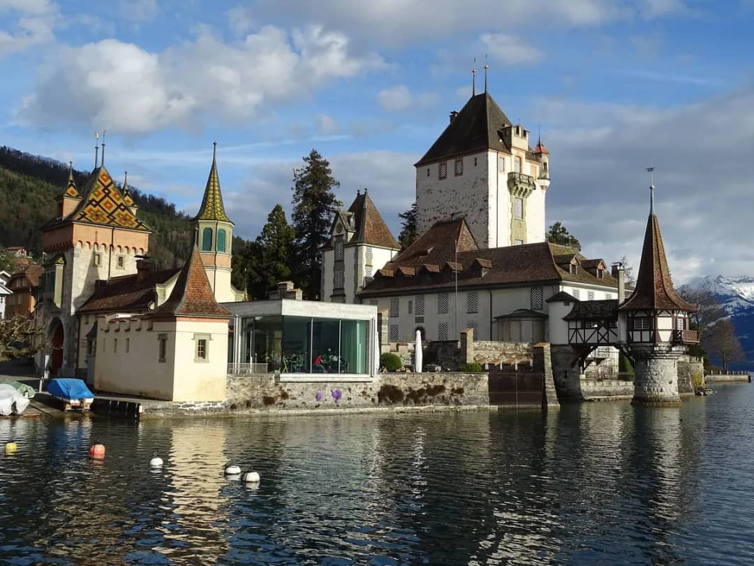 Schloss Oberhofen mit Seeturm und Glaspavillon, vom Thunersee aus gesehen, kahle Bäume im späten Winter