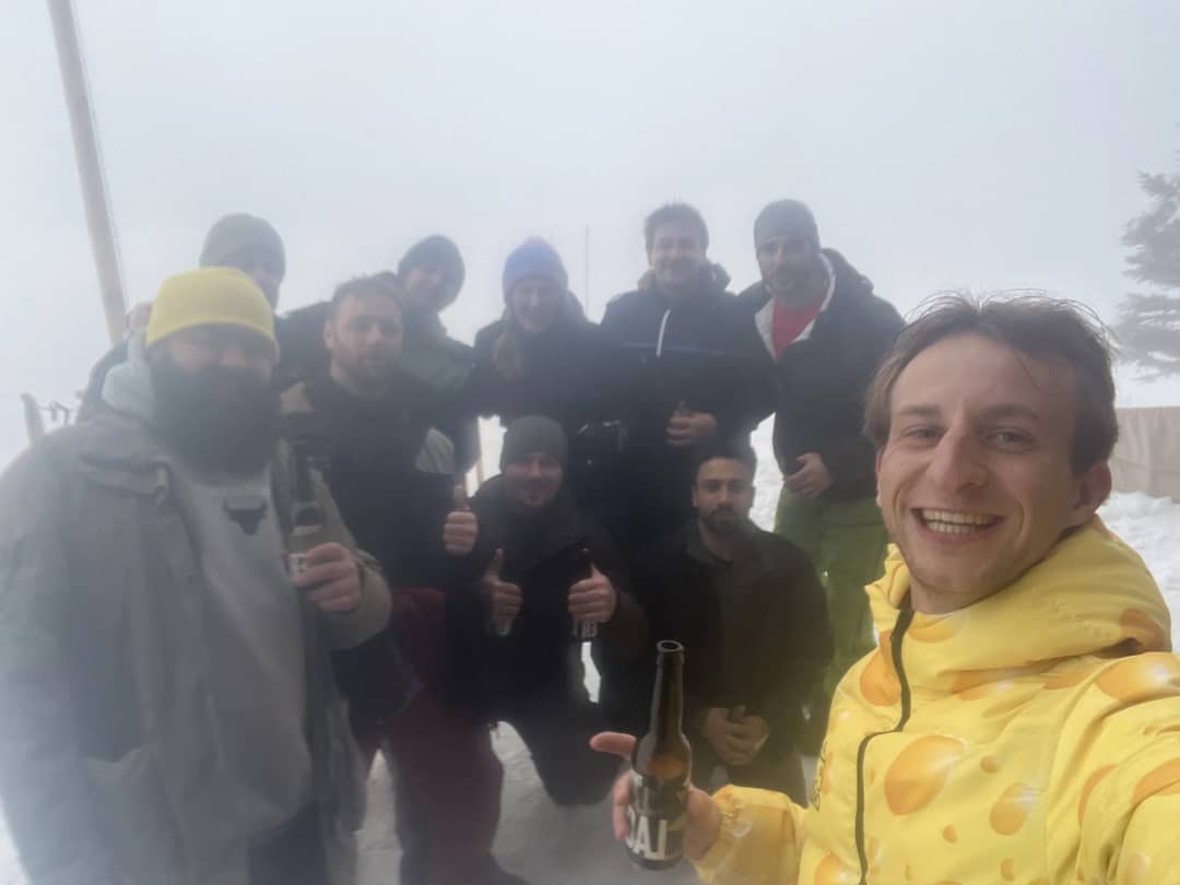 Group of friends with drinks in thick fog at the Allmendhubel above Mürren on a March afternoon