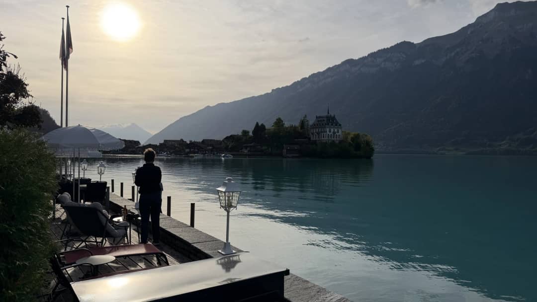 Low evening sun over Lake Brienz at Iseltwald, the pier and Seeburg peninsula in silhouette in September