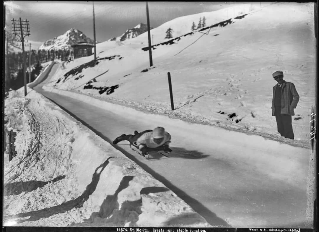 Black-and-white photo of a skeleton rider head first on the icy Cresta Run in St. Moritz, around 1907