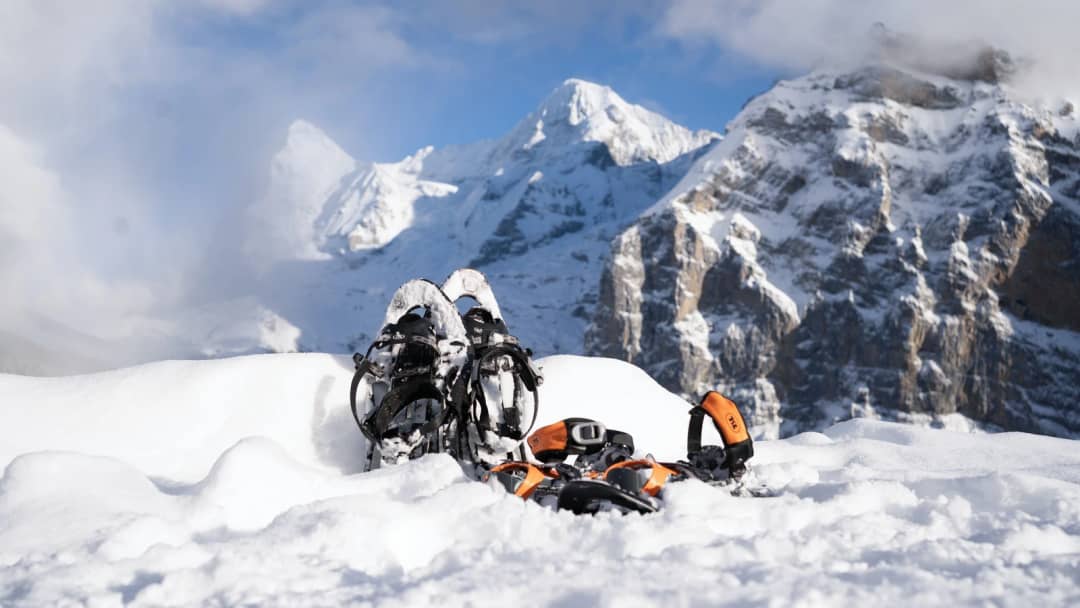 Raquettes et fixations dans la poudreuse au-dessus de Mürren, avec l'Eiger, le Mönch et la Jungfrau derrière