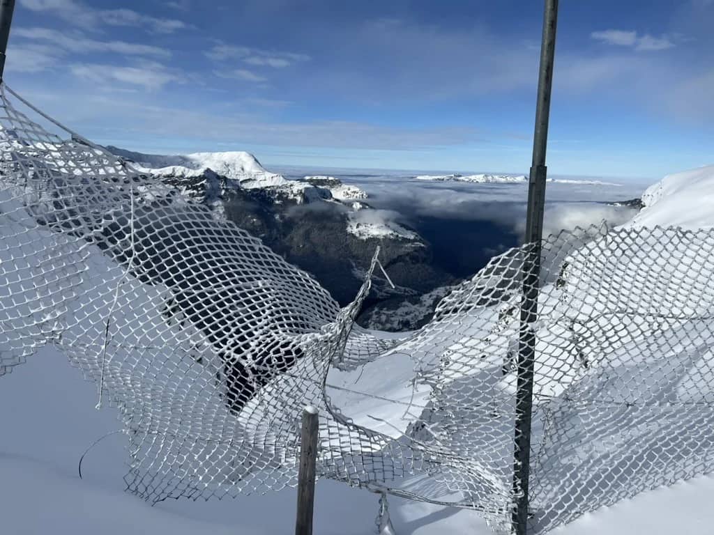 Pistenrand mit Zaun über dem Nebelmeer bei der Kleinen Scheidegg im Dezember, ein Werktag mit Skipass